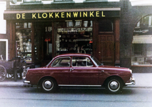 856004 Afbeelding van een geparkeerde auto voor De Klokkenwinkel van J. Kool (Voorstraat 15) te Utrecht.